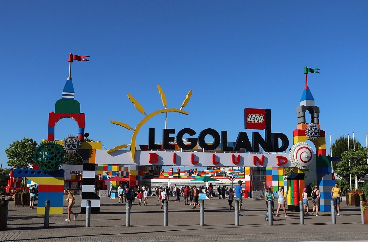 Wejście do Legolandu w Billund, z kolorowymi budowlami i odwiedzającymi.
